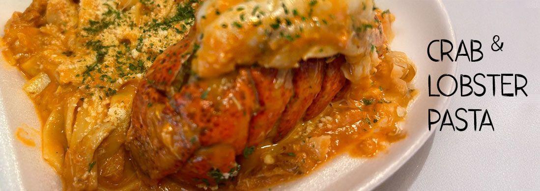 A white plate topped with crab and lobster pasta.